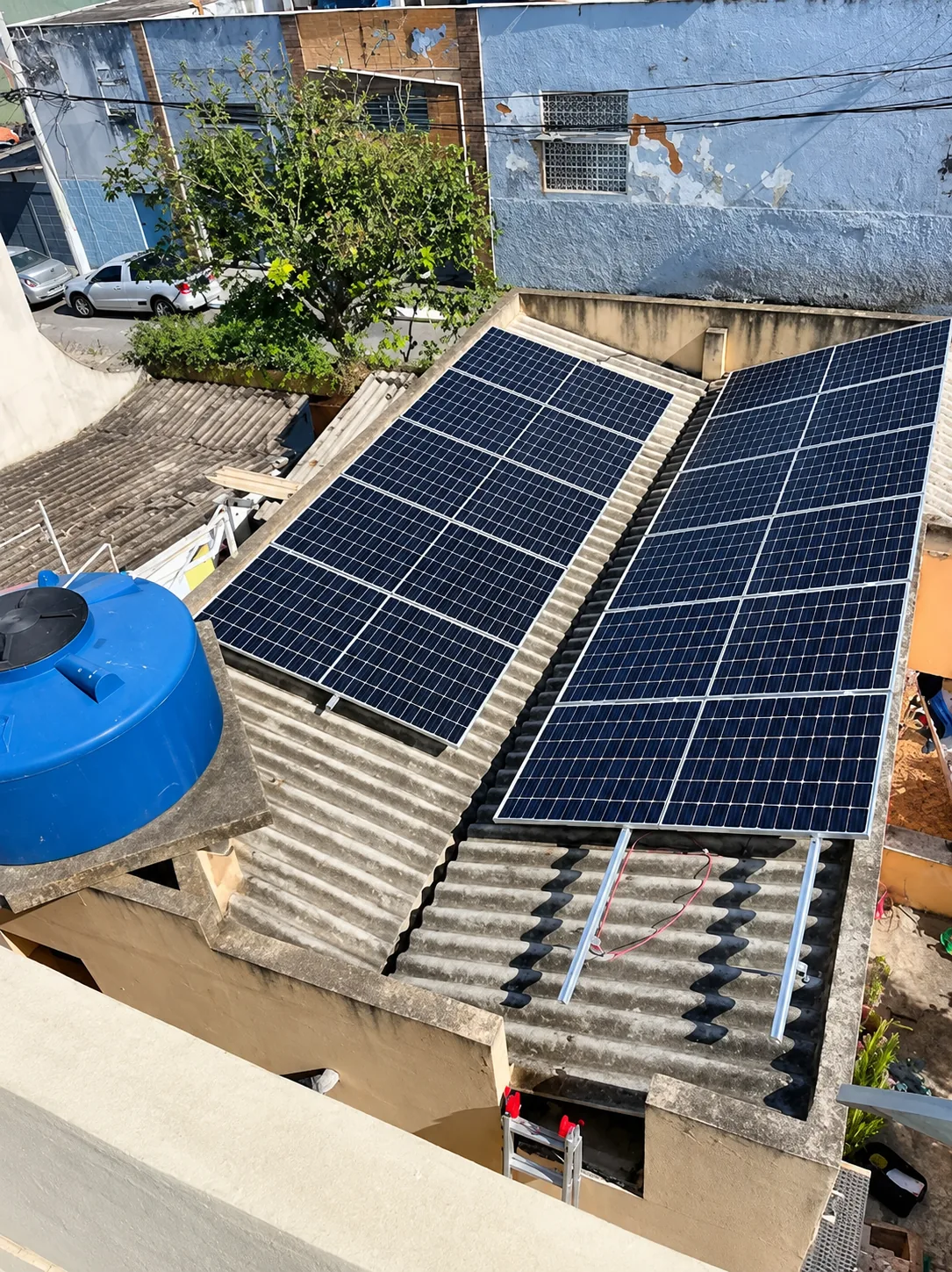 Dois conjuntos de painéis solares em telhado de fibrocimento